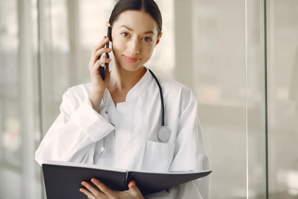 A medical professional in a white coat talking on a smartphone for Healthcare Medical Billing Services.